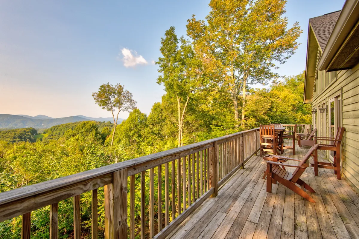 A serene deck furnished with comfortable seating provides a cozy spot to relax while taking in the mountain and tree-filled views. The atmosphere is quiet and inviting, ideal for both intimate gatherings and solo reflection.